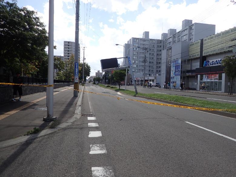 中央分離帯の両側の道路が陥没している.