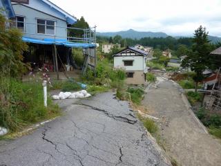 主滑落崖の変位.写真中央の道路の縁辺が滑落崖(変位約5m) 道路滑落部分から写真右側が地溝状の落ち込み(幅約15−20m)