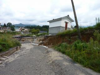 地溝状の落ち込みの部分.右側の宅地,畑地はすべり方向に階段状に変形している