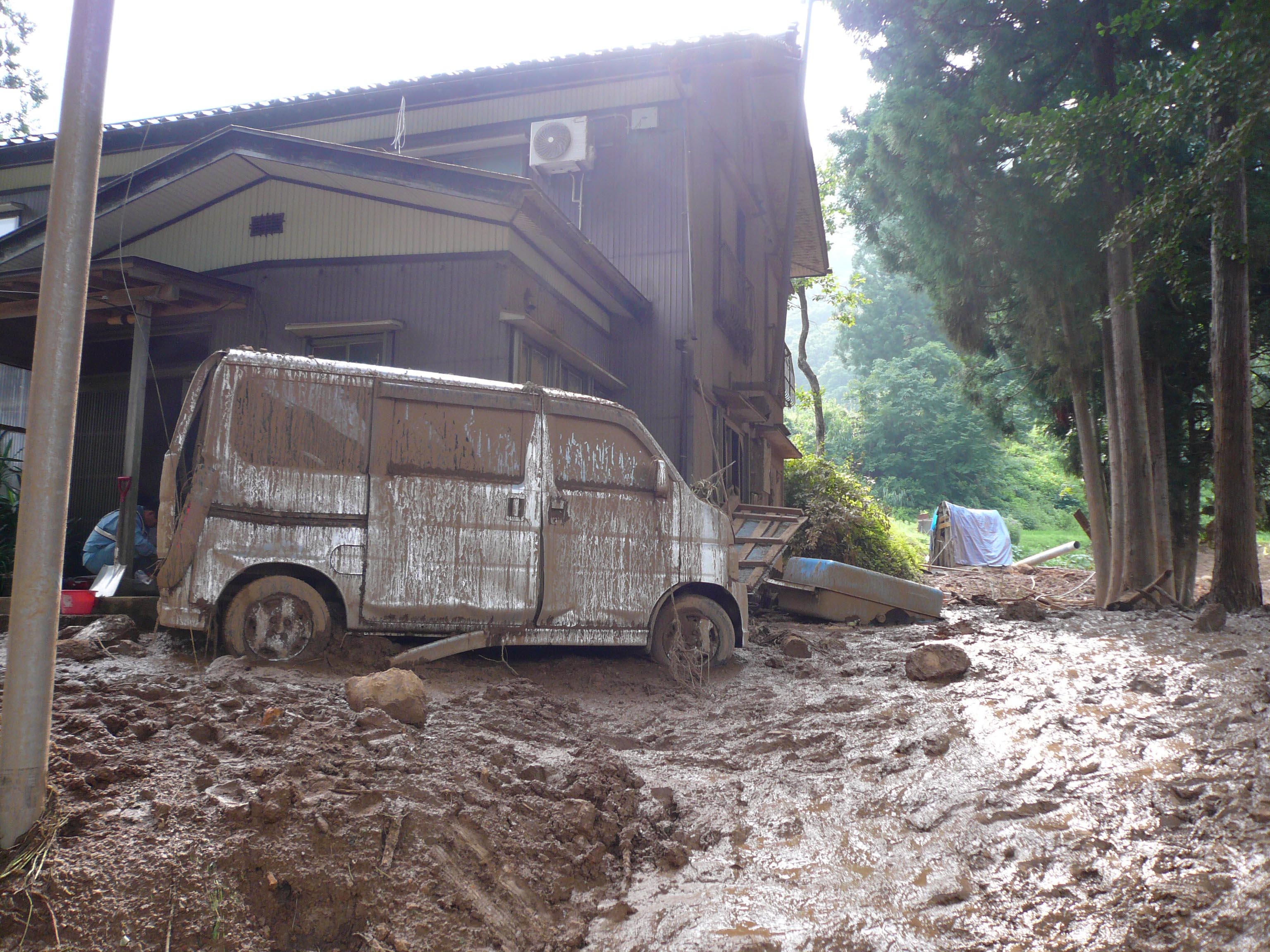 写真15 住宅は地すべり地形の底部から比高5m程度の高い部分に位置しているが,流動性の高い土砂をかぶり一部損壊している.