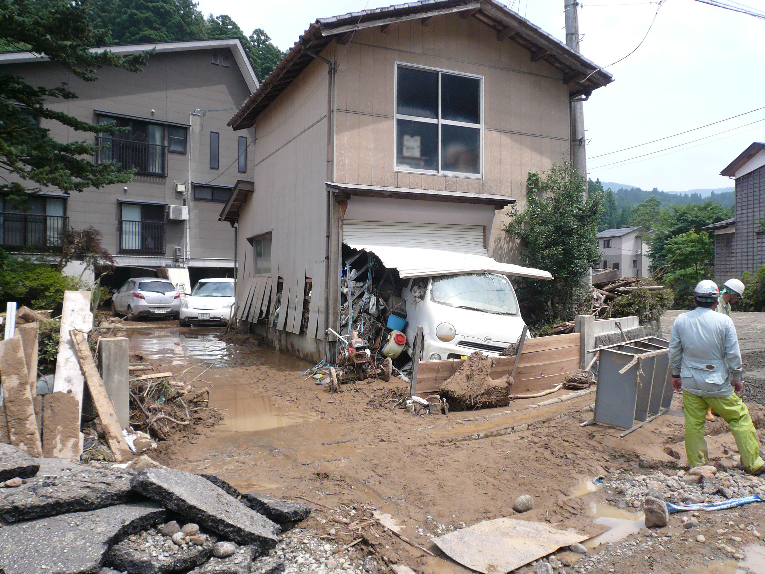 写真6 集落中央部(集落内での乙吉川の中流部)の被害状況:浸水深150-160cm(道路面から),床上浸水90-100cm程度,車両の流出あり