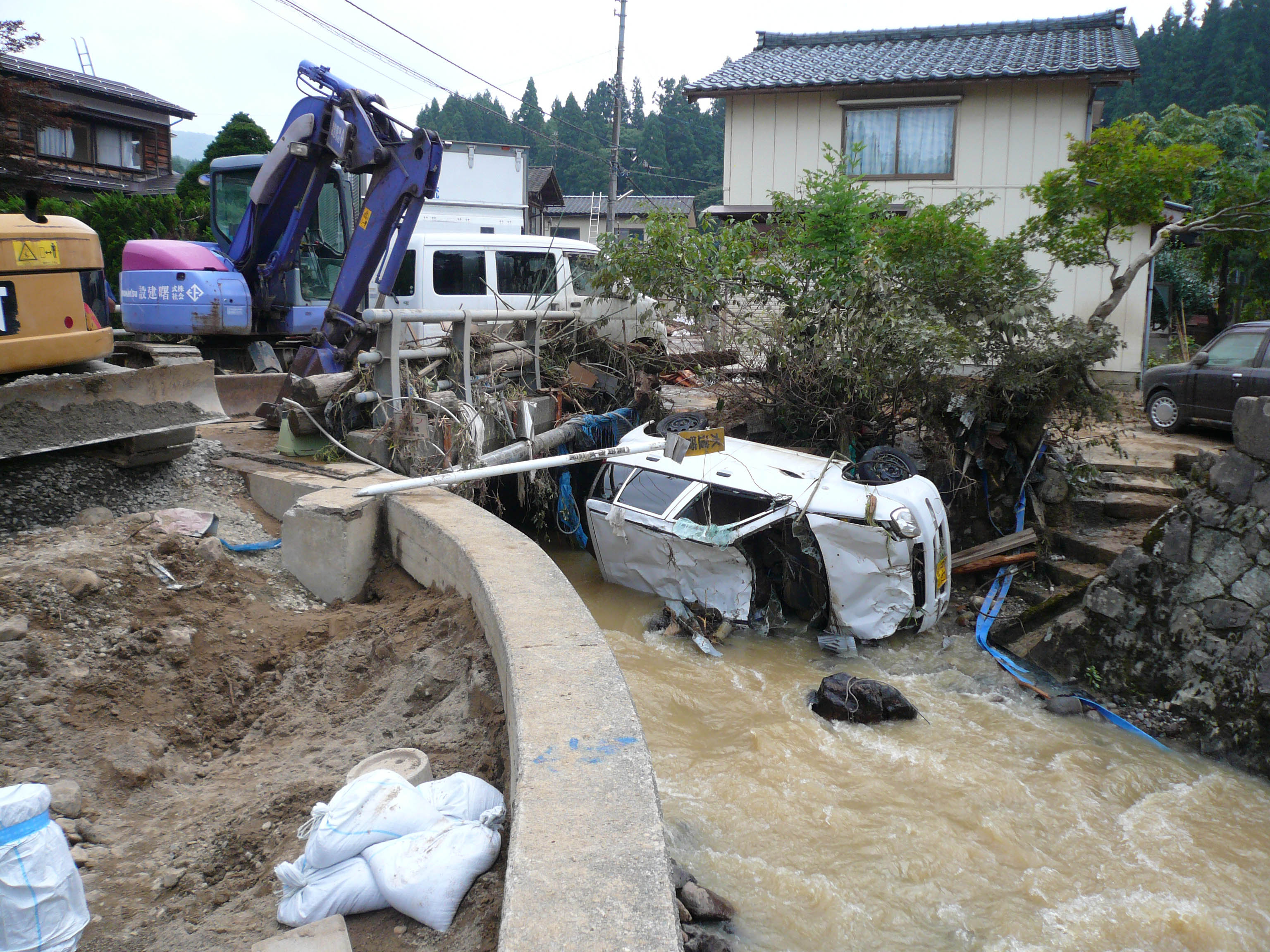 写真7 集落中央部(集落内での乙吉川の中流部)の被害状況:浸水深150-160cm(道路面から),床上浸水90-100cm程度,車両の流出あり